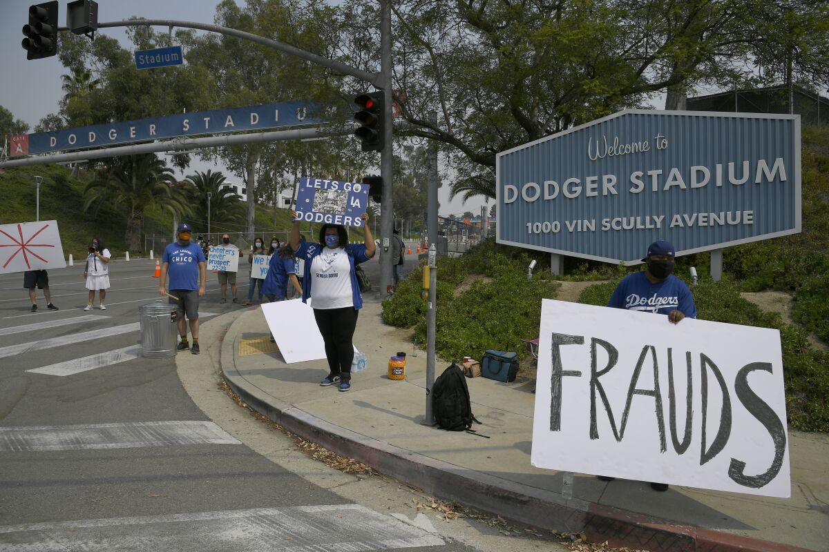 Fans stand outside Dodger Stadium ready to boo the Astros as they arrive on Sept. 13, 2020