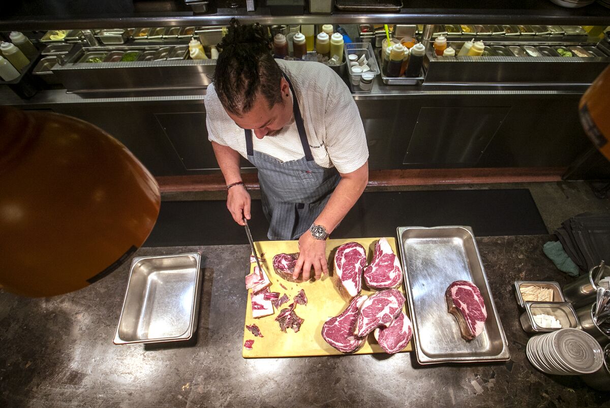 Chef Amar Santana cuts a 55-day dry-aged ribeye at Vaca restaurant in Costa Mesa.
