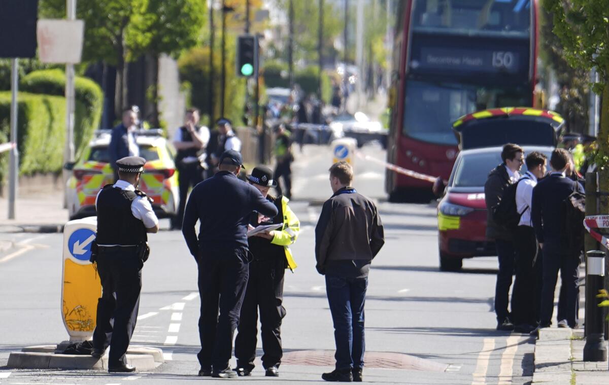 Police talk to members of the public at the scene of the stabbing attack in London.