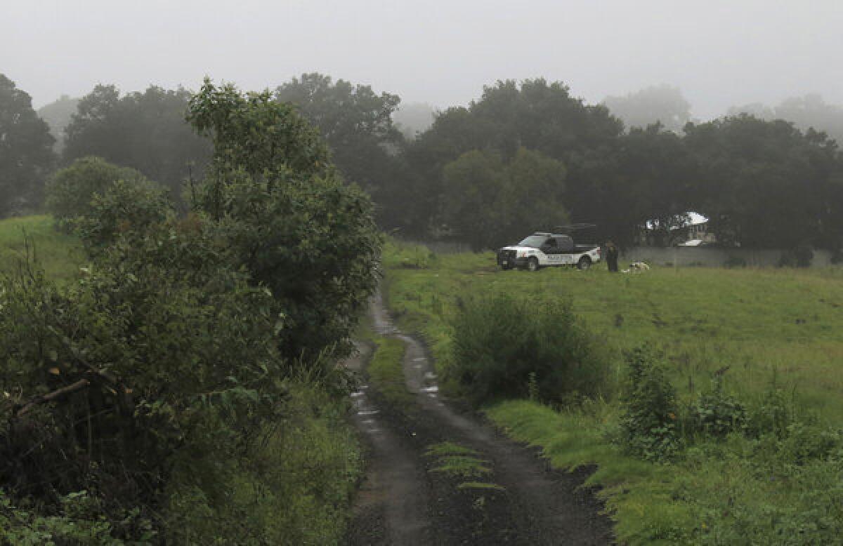 A police vehicle sits at a ranch in Tlalmanalco, outside Mexico City, where five bodies found in a mass grave were identified as those of young people who disappeared from a bar in the capital three months ago.