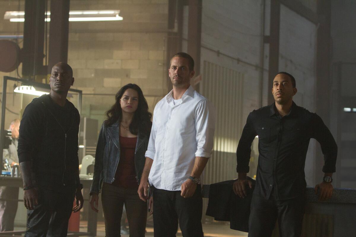 Tyrese Gibson, from left, Michelle Rodriguez, Paul Walker and Chris "Ludacris" Bridges in a scene from "Furious 7."