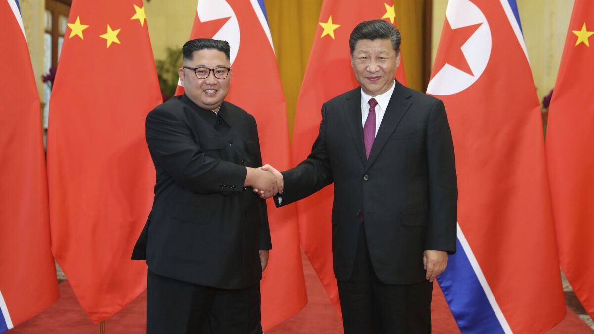 Chinese President Xi Jinping, right, poses with North Korean leader Kim Jong Un in Beijing in June 2018.