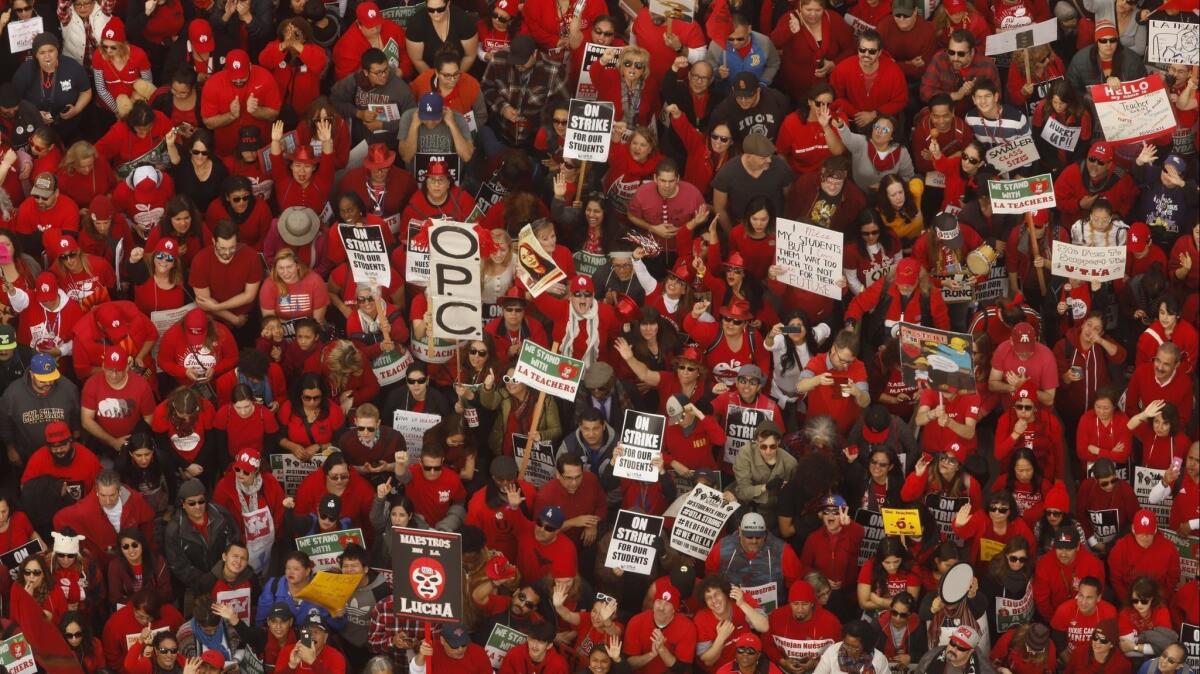 Striking teachers and supporters turned out by the thousands, making a sea of red Friday in a rally at Grand Park.