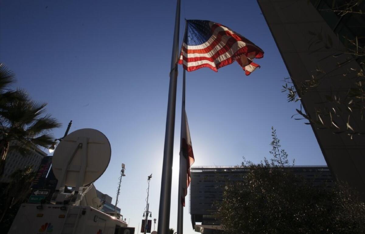 The flag in front of LAPD headquarters flies at half-staff for law enforcement officers believed to have been killed by former LAPD officer Chris Dorner.