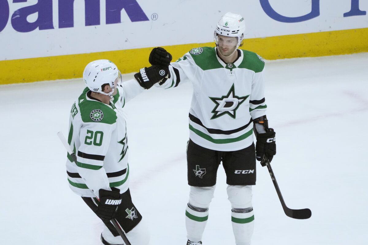 Dallas Stars' Colin Miller (6) celebrates his goal against the Chicago Blackhawks with Ryan Suter during the first period of an NHL hockey game Tuesday, March 28, 2023, in Chicago. (AP Photo/Charles Rex Arbogast)