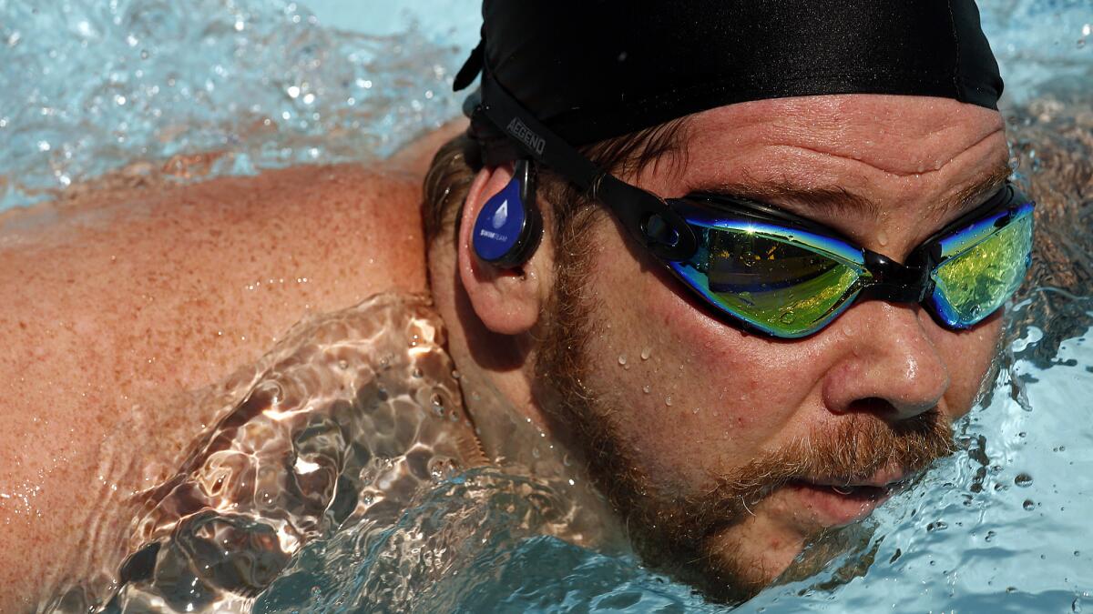 WEST HOLLYWOOD, JULY 16, 2017 -- Zeffin Quinn Hollis wears a head set that allows him to hear music and instructions from a coach during a Swim Team class at the West Hollywood Aquatics Center in West Hollywood on July 16, 2017. The Swim Team classes are held at pools around Los Angeles and combines lap swim with exercise intervals, with a headset that allows you to hear music and coaching, even underwater. (Genaro Molina/Los Angeles Times)