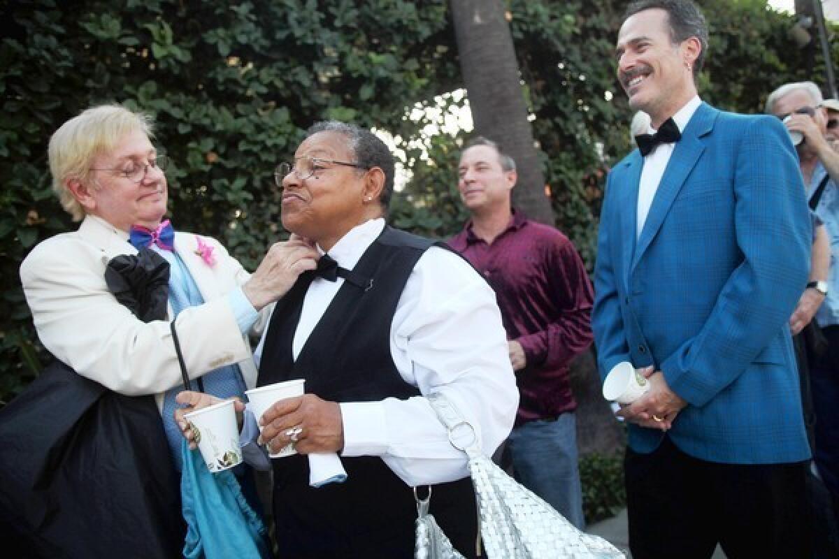 Russ Ford, left, helps Beverly Winter adjust her bow tie while waiting in line for the Los Angeles Gay and Lesbian Center's senior prom.
