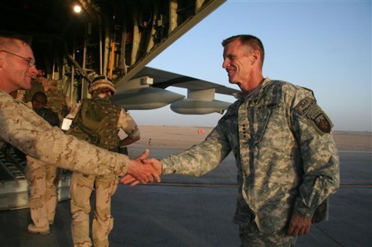 The head of U.S. and NATO forces in Afghanistan, U.S. Gen. Stanley McChrystal, right, shakes hands with a marine before boarding a military plane at the Camp Leatherneck base in the southern province of Helmand, Wednesday, June 24, 2009. (AP Photo/Jason Straziuso)