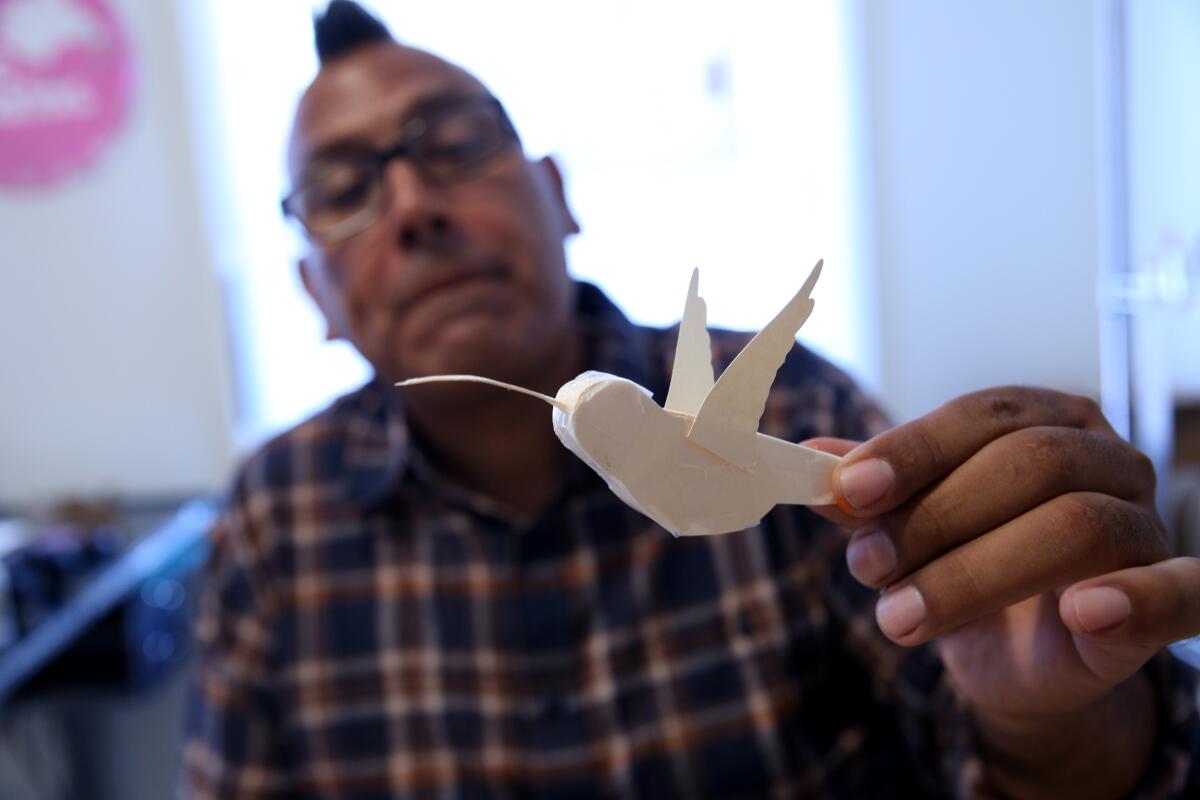 Isaías Rodríguez muestra una mini piñata sin terminar con forma de colibrí.