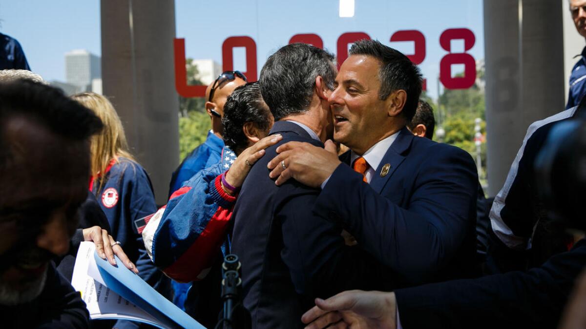 Los Angeles Mayor Eric Garcetti is congratulated by council member Joe Buscaino at a news conference to announce the city's approval of a deal to host the 2028 Olympics.