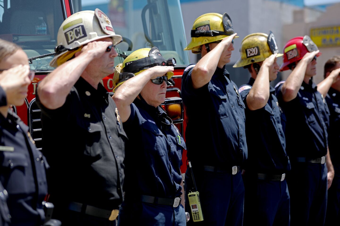 Long Beach firefighters salute as a procession carries Fire Capt. Dave Rosa, 45, to the Los Angeles County coroner's office on Monday.