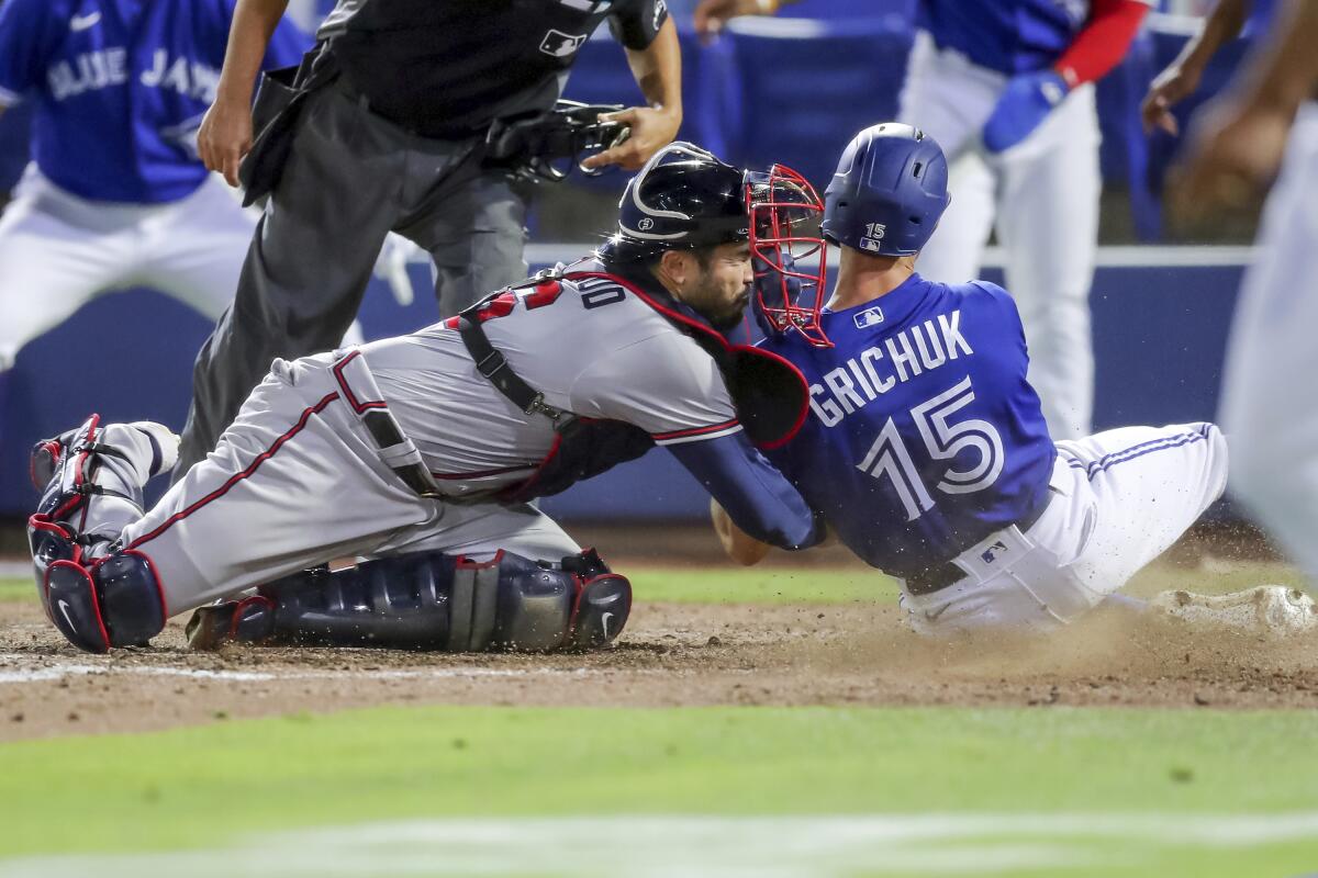 Atlanta Braves catcher Travis d'Arnaud tags out Toronto Blue Jays' Randal Grichuk during the sixth inning of a baseball game Saturday, May 1, 2021, in Dunedin, Fla. (AP Photo/Mike Carlson)