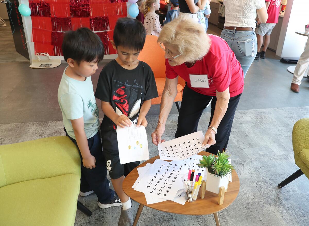 Lara Cinar's grandmother, Lusvart Cepkinian helps kids at the Boys and Girls Club with the Armenian alphabet. 