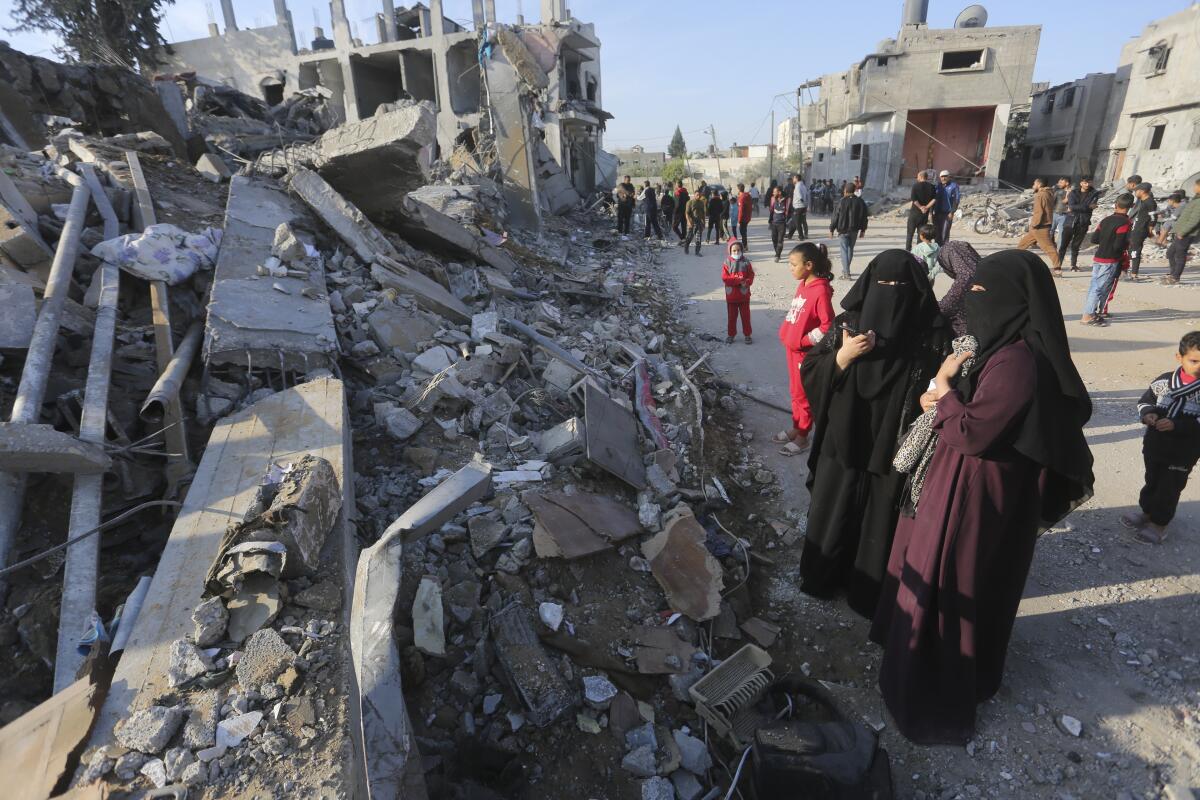 Palestinos observan la destrucción causada por el bombardeo israelí de la Franja de Gaza en Rafah,