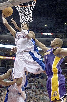 Los Angeles Clippers' Mikki Moore, left, dunks over Los Angeles Lakers' Caron Butler.