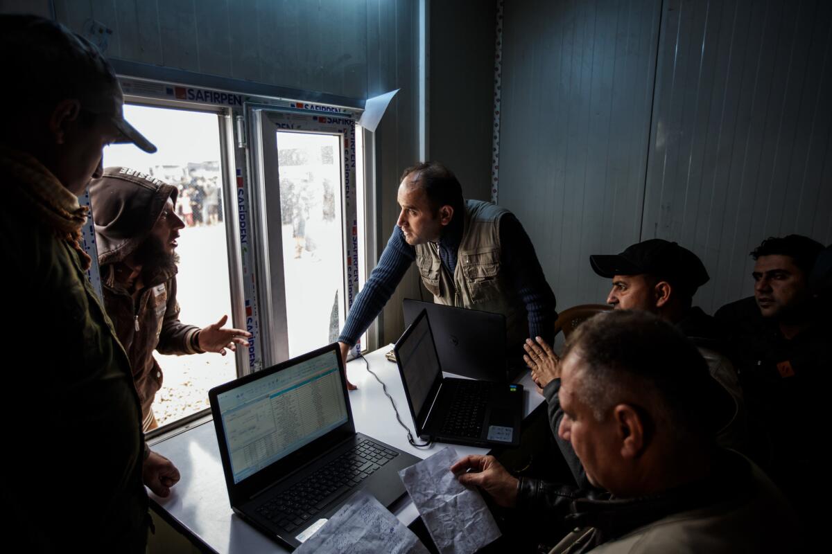 Members of Community Policing, a part of the Baghdad government, ask questions of civilians as they check identifications with their database.