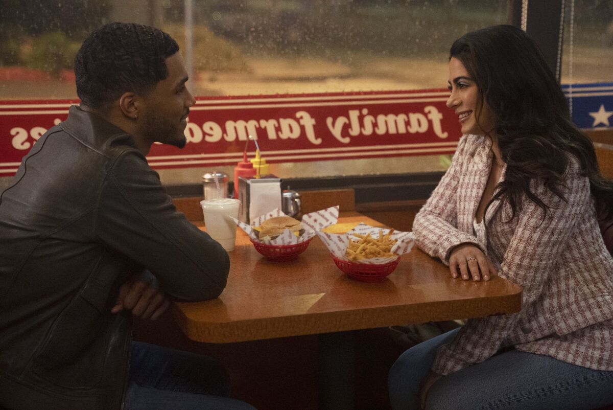 A man and a woman talking over fries at a diner