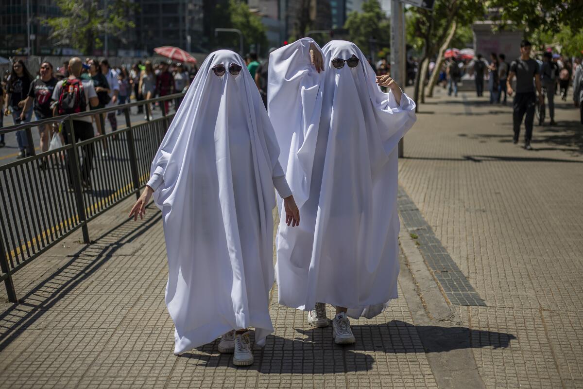 People in ghost costumes walking along a street