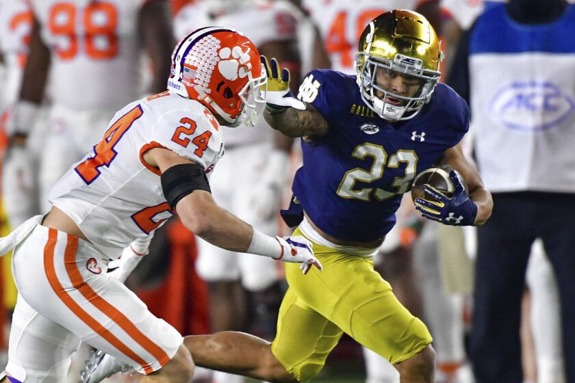 Notre Dame's Kyren Williams wards off Clemson safety Nolan Turner on a touchdown run Nov. 7, 2020.