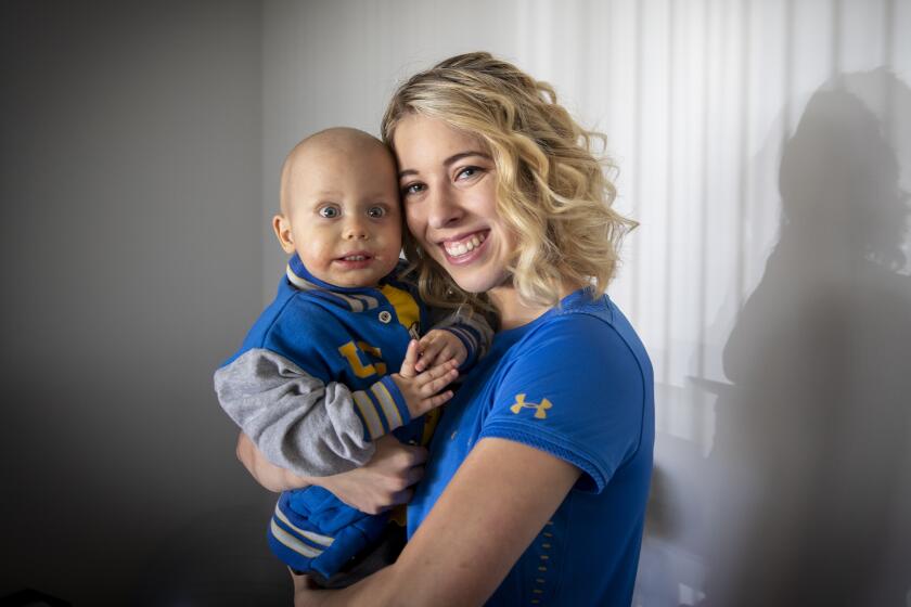 UCLA gymnast Mercedez Sanchez holds her 1-year-old brother Liam Clark.