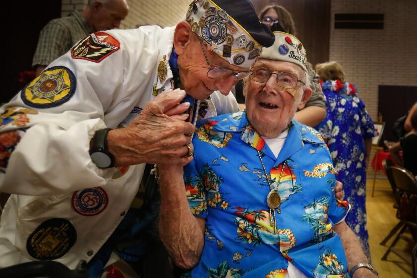Howard Lipin  U-T Stuart Hedley, 97 (left), president of the San Diego chapter of the Pearl Harbor Survivors Association, greets member Clayton Schenkelberg, 101, at their final official meeting Saturday.