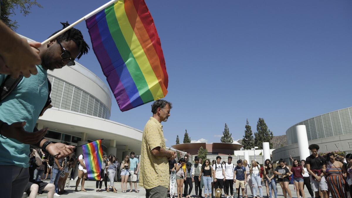 Rob Muthiah, a professor of practical theology, offers a prayer during a rally by the LGBTQ Christian community at Azusa Pacific University.