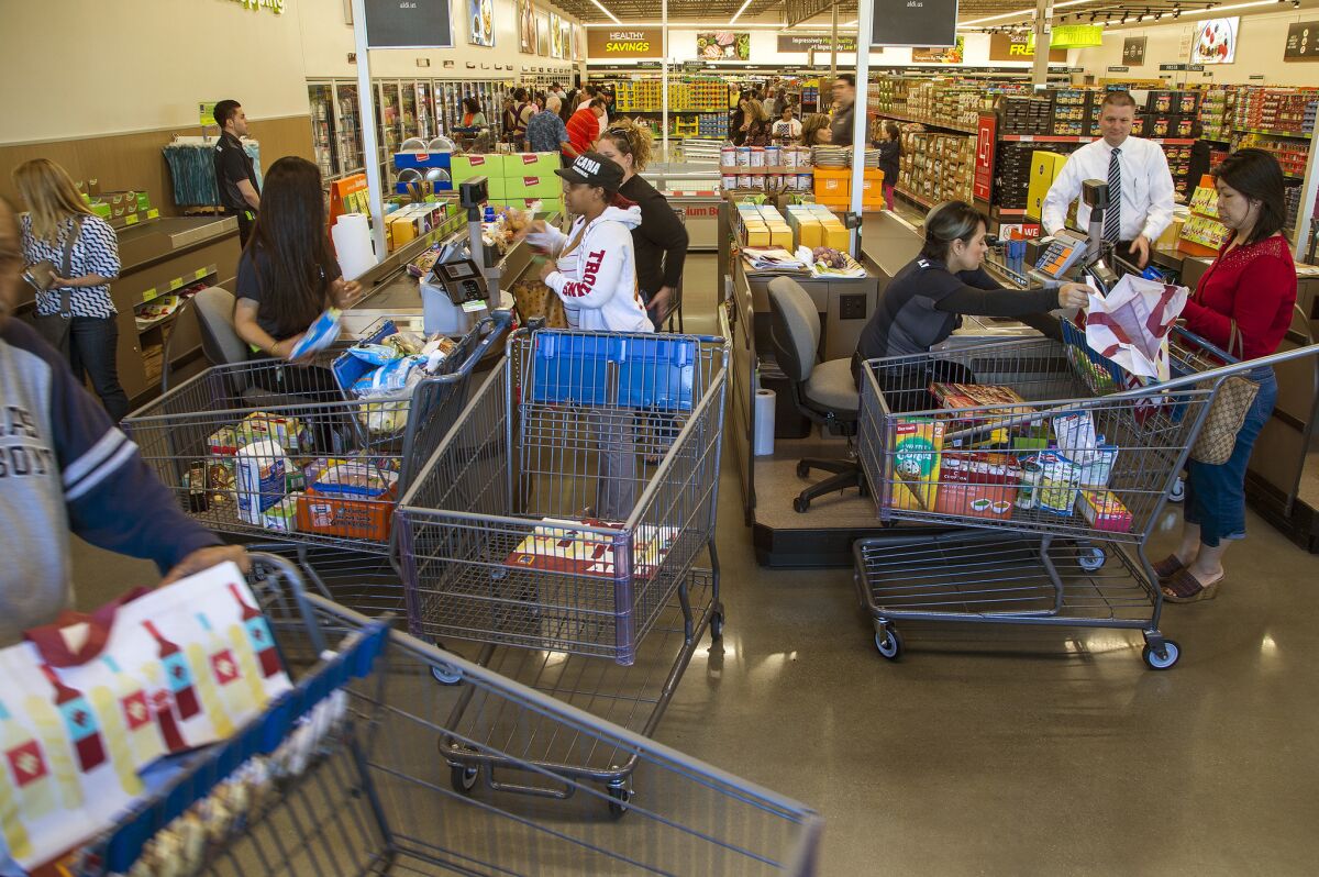 Shoppers pay for groceries at Aldi in Moreno Valley in this March file photo.