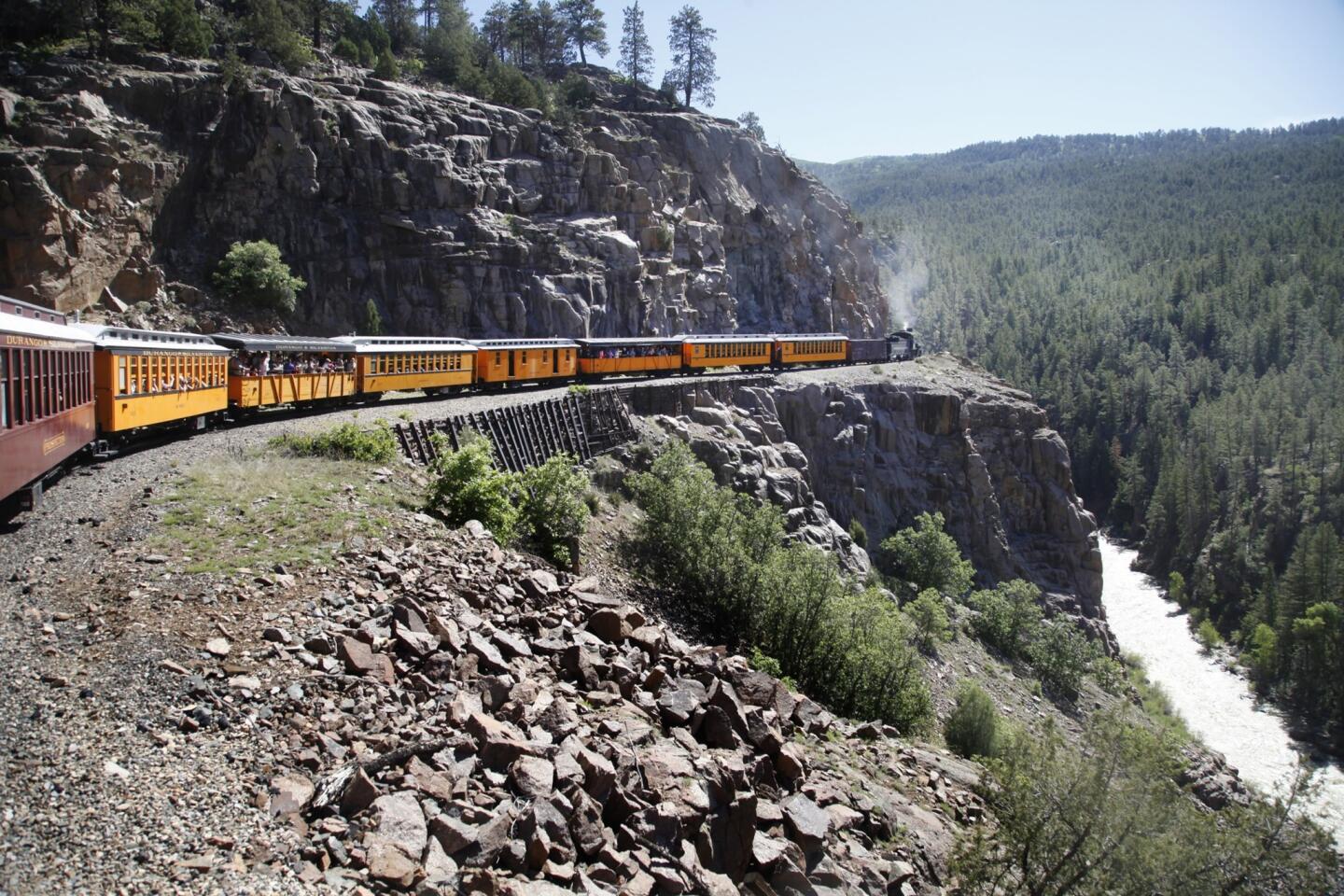 The Durango & Silverton Narrow Gauge Railroad -- formerly the Denver & Rio Grande Railway -- chugs down the grade on the Highline above Animas Canyon and the rushing river below.