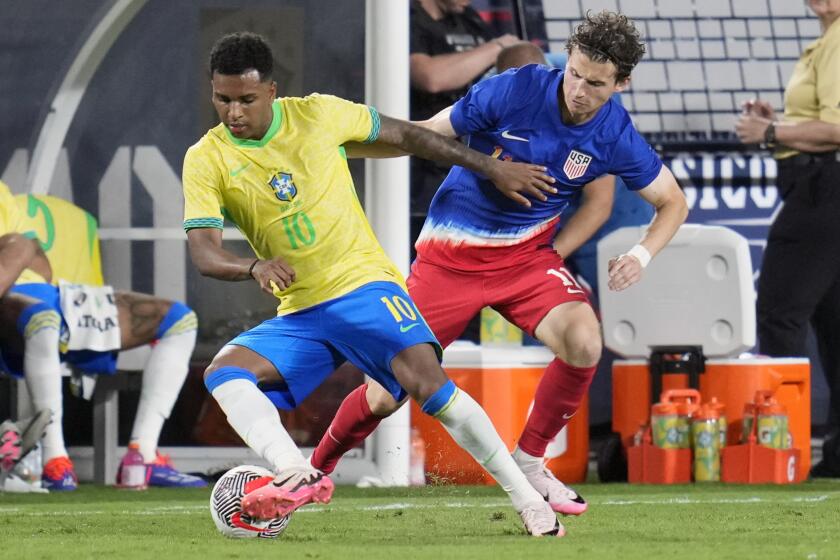 Brazil forward Rodrygo, left, moves the ball past U.S. forward Brenden Aaronson during the second half of an international friendly soccer match Wednesday, June 12, 2024, in Orlando, Fla. (AP Photo/John Raoux)
