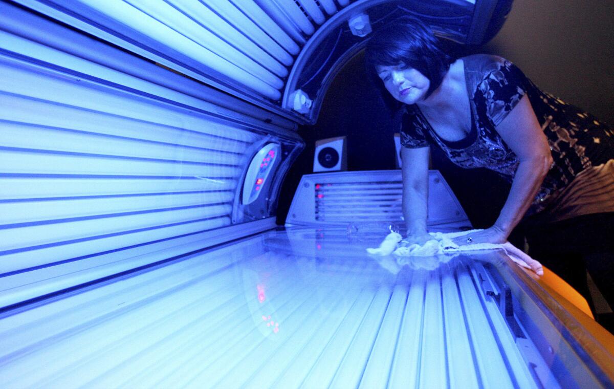 The FDA hopes to discourage teenagers from using tanning beds and booths. Above, Teresa Lynch, owner of Dynamic Tanning, wipes down a bed in DeKalb, Ill.