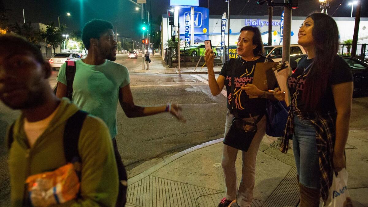 Midnight Stroll activists Angela Cristobal, right, and Teanna Herrera talk with passersby Friday night on Santa Monica Boulevard in Hollywood.