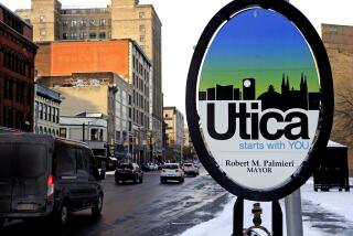 Vehicles move along Genesee Street in the early morning after a fresh snowfall, in Utica, N.Y.