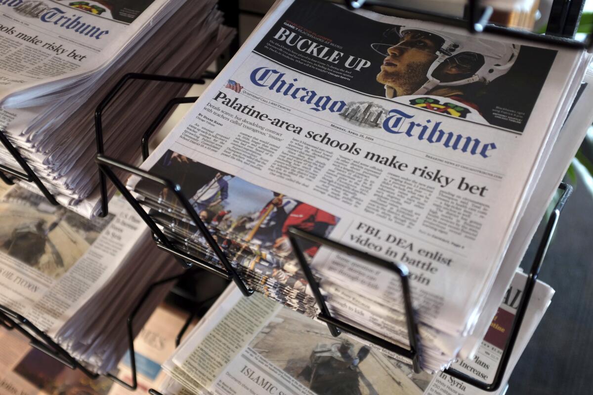 Copies of Chicago Tribune newspapers sit in a rack. 