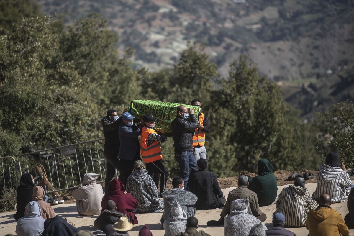 People carry the coffin of 5-year-old Rayan during his funeral after his body was retrieved from a deep well, in the village of Ighran in Morocco's Chefchaouen province, Monday, Feb. 7, 2022. Five-year-old Rayan was pulled dead from a 32-meter (105 foot) deep dry well where he was trapped for five days. (AP Photo/Mosa'ab Elshamy)