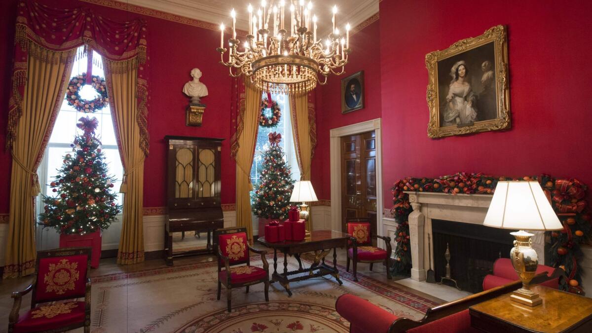 Inspired by First Lady Michelle Obama's "Let's Move!" campaign, oranges, apples, and pomegranates mix with greens to create wreaths in the Red Room, along with gift boxes made out of cranberries.