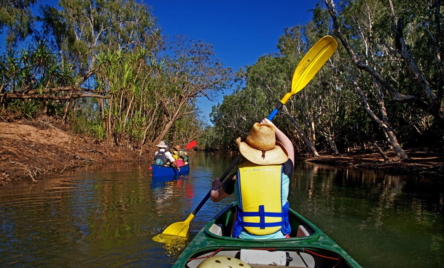 Canoeing on the Katherine River, which flows through Arnhem Land and Kakadu National Park. The river runs through the 13 flaming red-walled gorges that make up the Katherine Gorge of Nitmiluk Park, and past the namesake town of Katherine.
