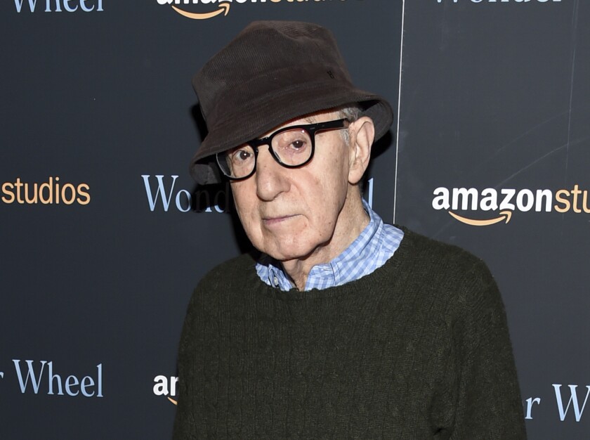 Woody Allen wearing glasses, a sweater and a hat