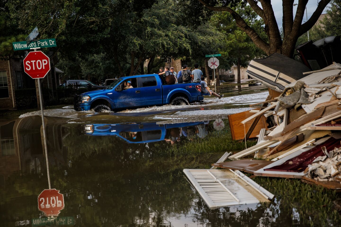 People ride through floodwaters in Katy, Texas.