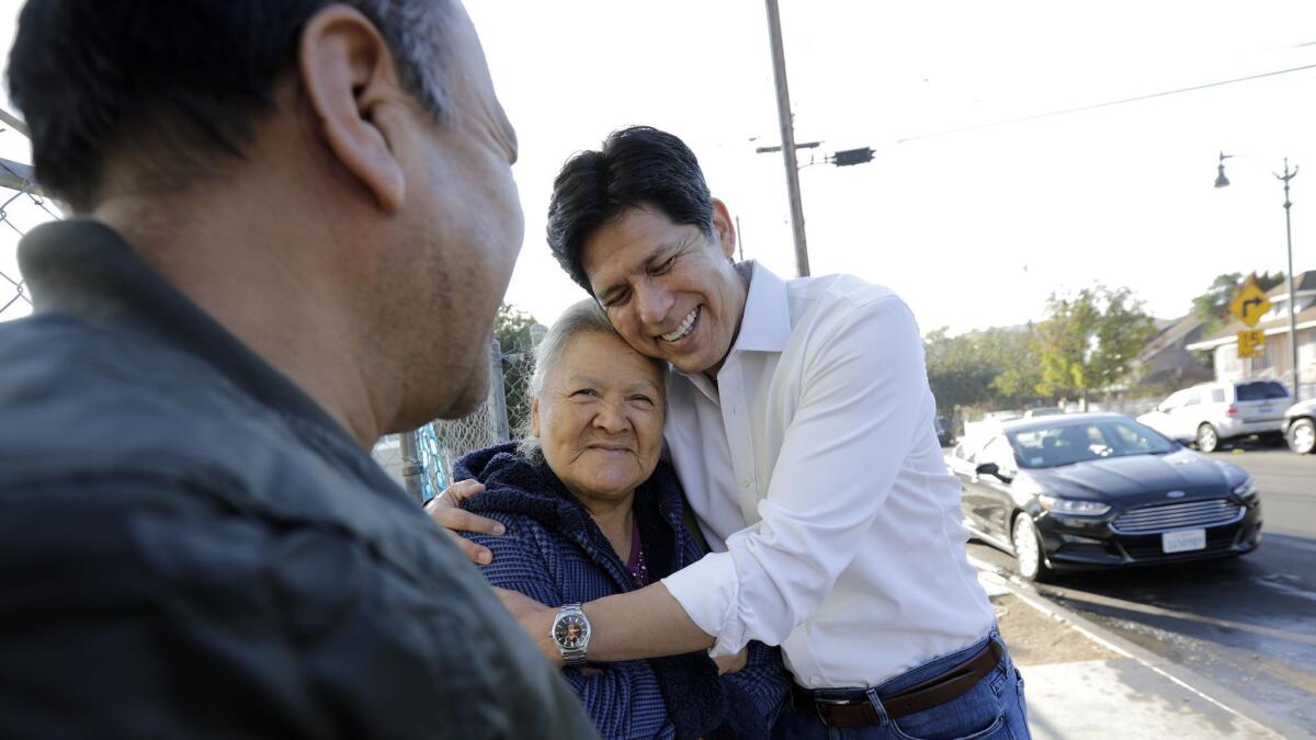 California state Sen. Kevin de León, right, a candidate in the U.S. Senate election in California, chats with Leobarda Loyola, 76, and her brother Juan Loyola, 60, left, on his way to La Abeja restaurant in Los Angeles.