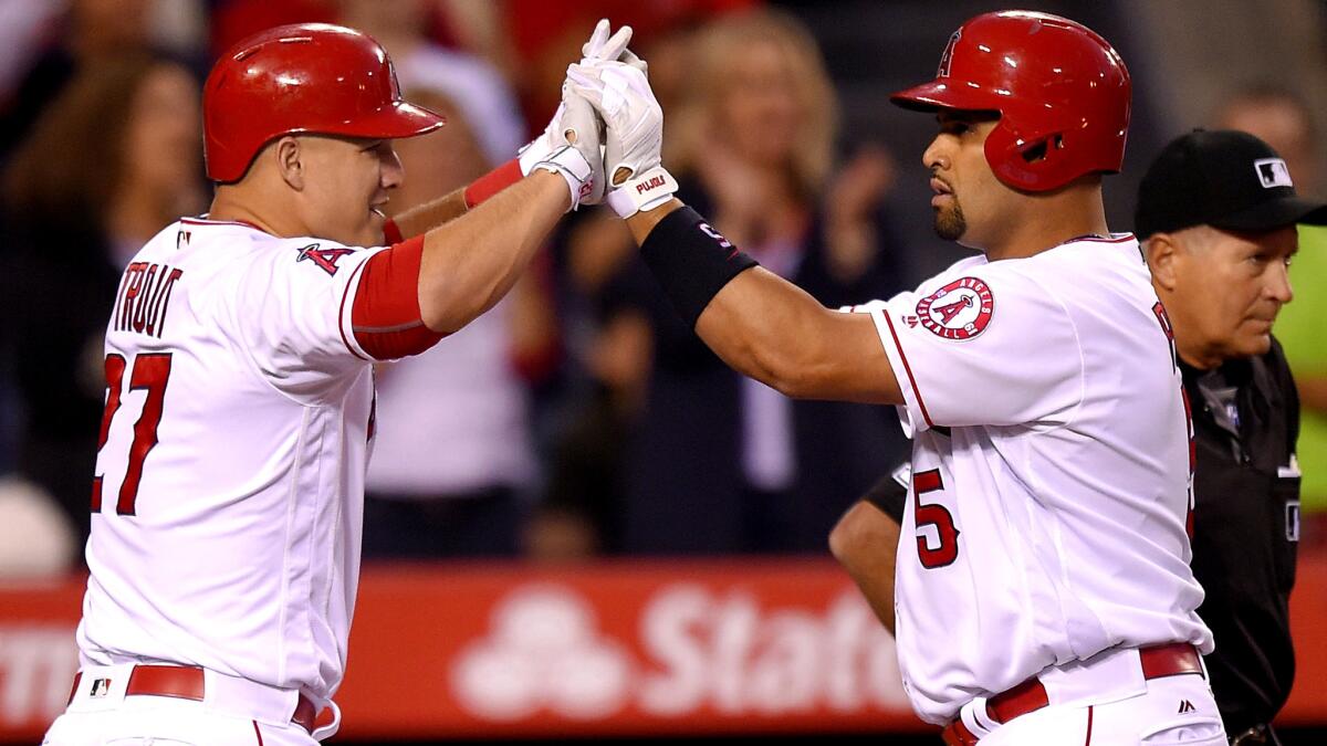 Angels center fielder Mike Trout (27) congratulates teammate Albert Pujols (5) after he hit a two-run home run against the Astros on Friday night.