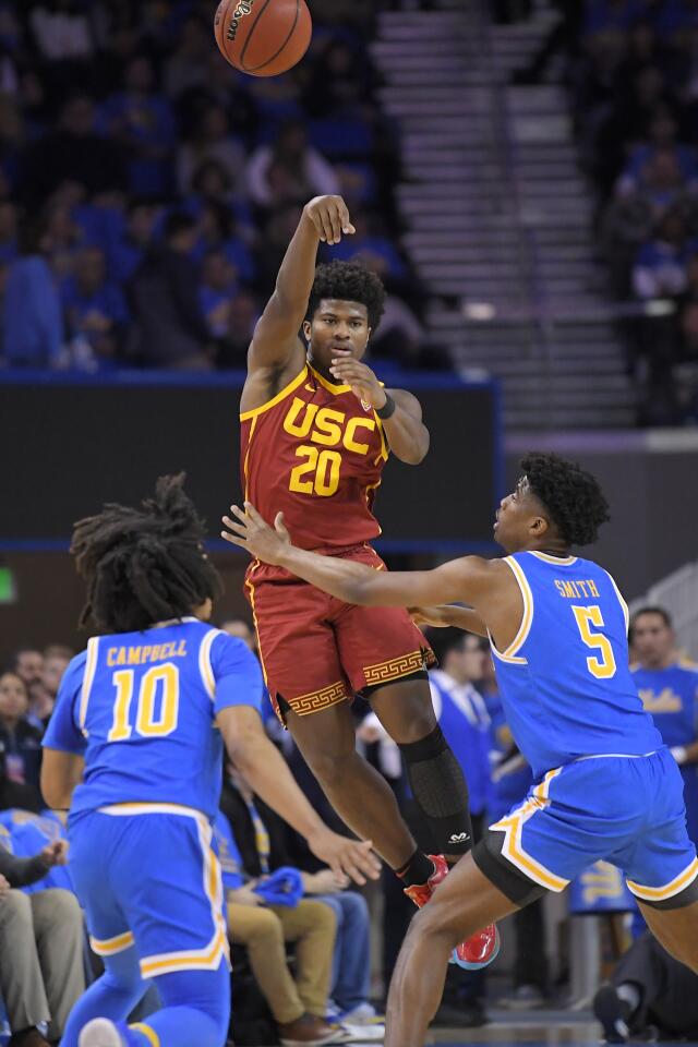 USC guard Ethan Anderson passes the ball over UCLA guards Tyger Campbell (10) and Chris Smith (5) during a game Jan. 11 at Pauley Pavilion.