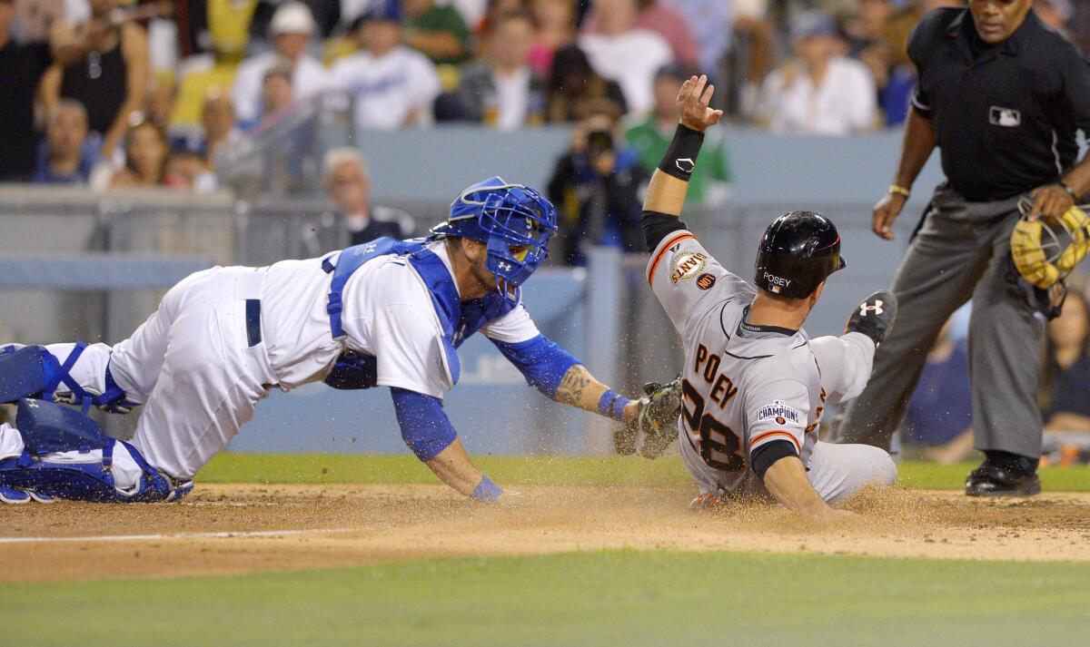 San Francisco's Buster Posey scores ahead of the tag by Dodgers catcher Yasmani Grandal on Friday night.