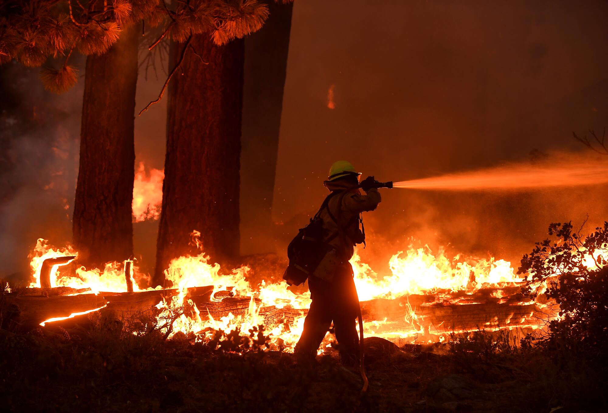 Firefighters battle the Caldor fire along Highway 89 west of Lake Tahoe 