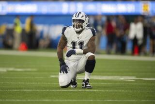 Cowboys linebacker Micah Parsons (11) kneels on the field to rest for a play.