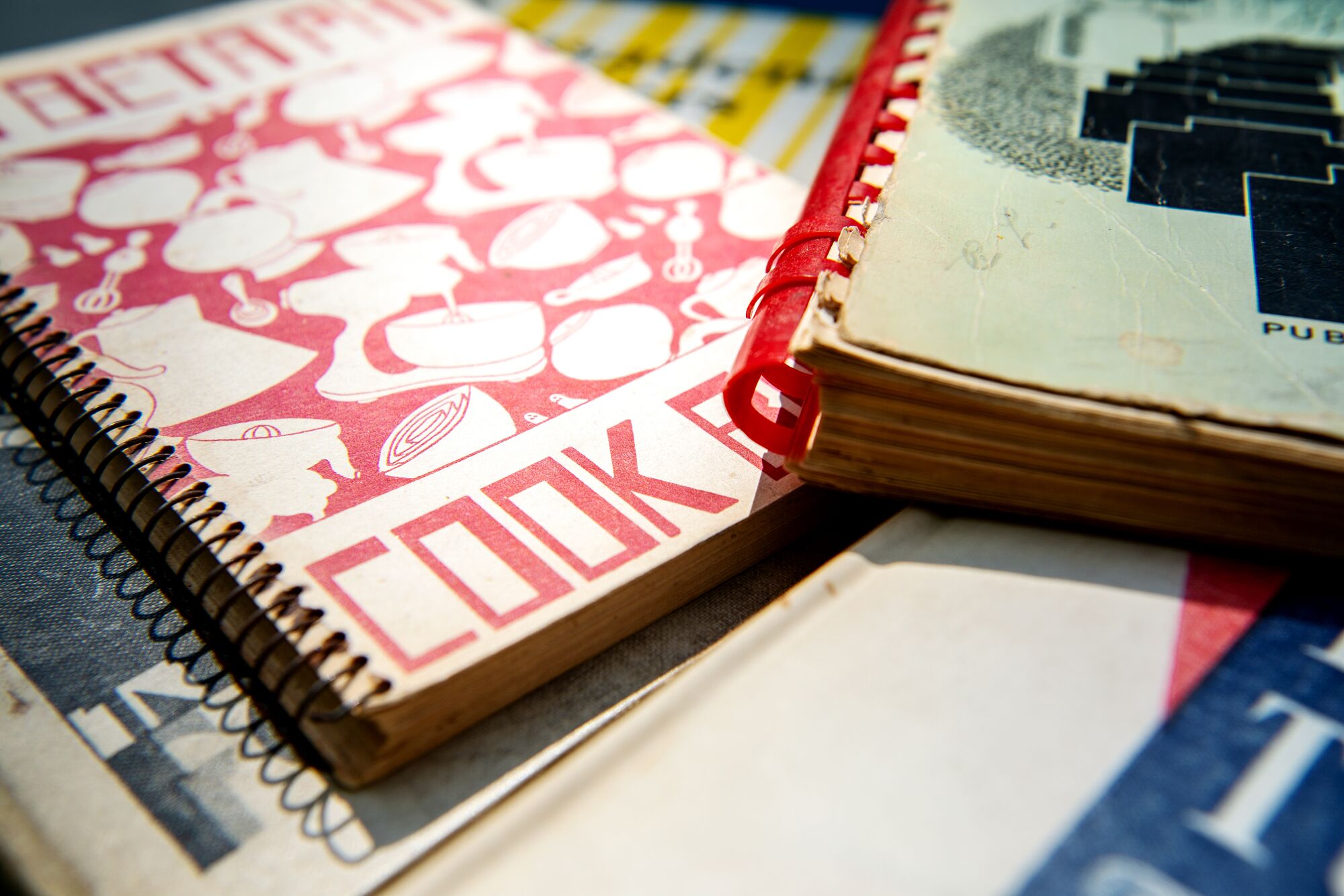 A closeup of several spiralbound vintage cookbooks.