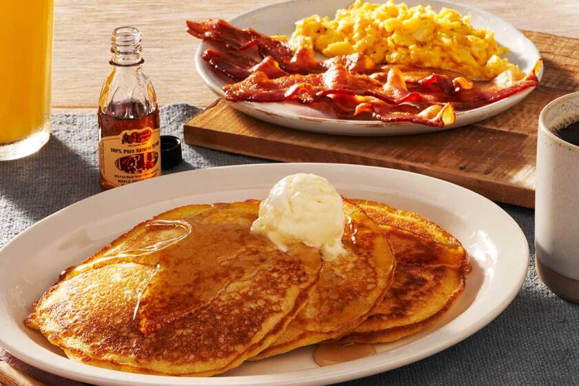 A plate of butter-topped pancakes, eggs and bacon from Cracker Barrel Kitchen.