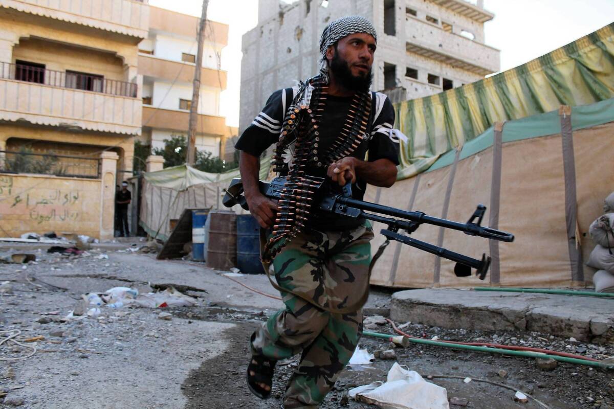 An opposition fighter runs past an area known for sniper fire in Dair Alzour last week.