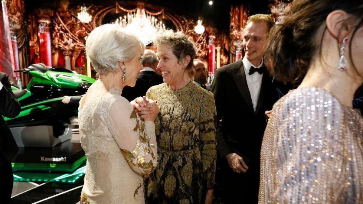 Helen Mirren, left, congratulates lead actress winner Frances McDormand after the close of the 90th Oscars -- with the prize jet-powered ski in the background and "The Shape of Water" star Doug Jones on the right.
