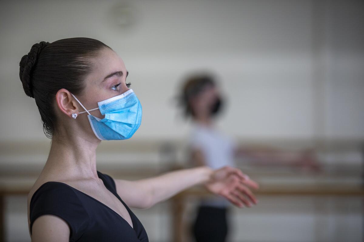 Close up photo of a young female ballet dancer wearing a mask. 