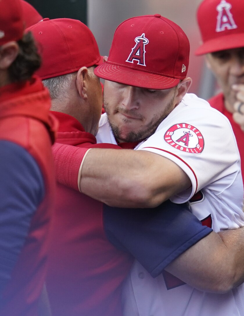 Angels center fielder Mike Trout, right, hugs interim manager Phil Nevin before Tuesday's game against the Red Sox.